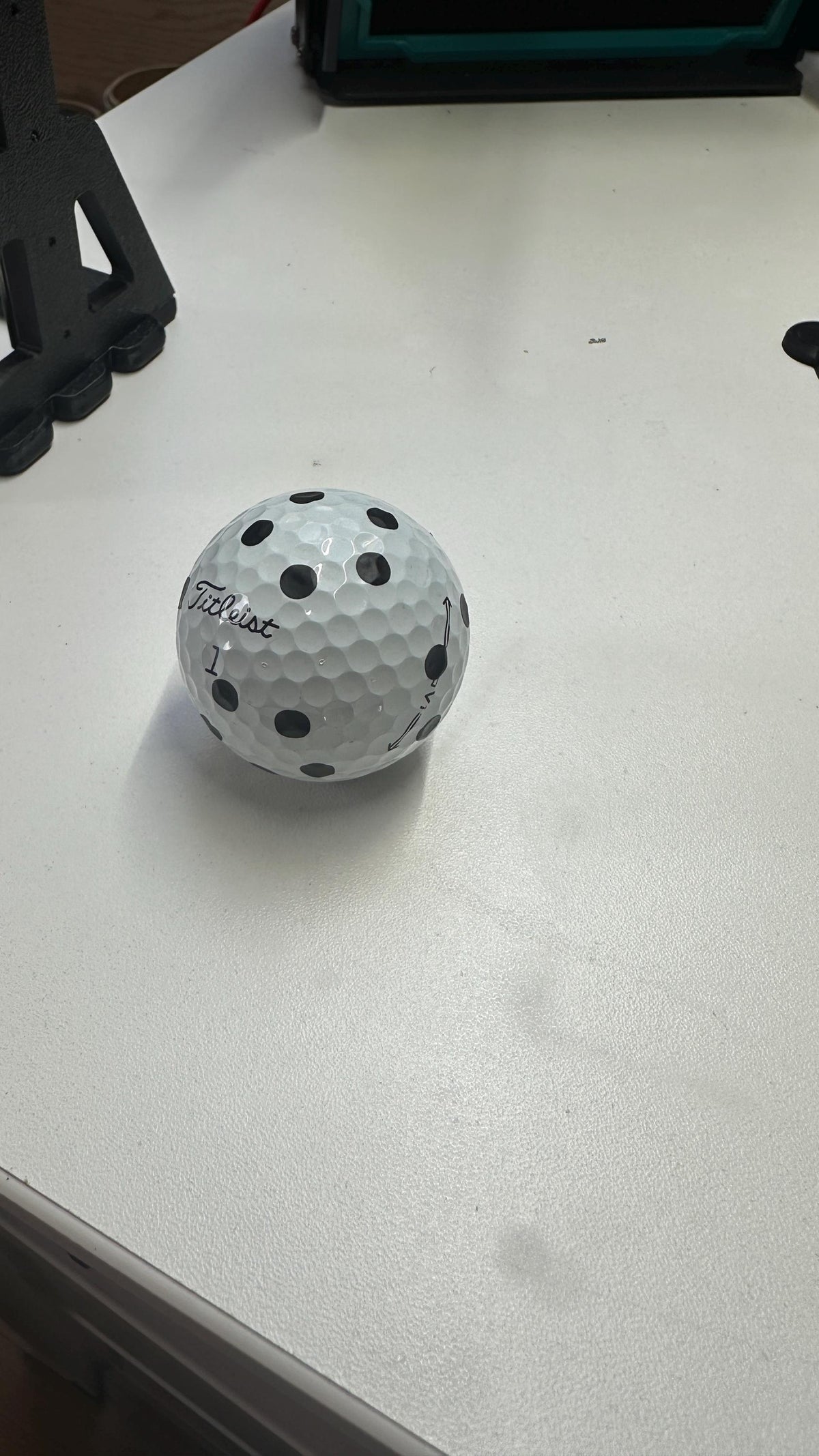 Marked golf ball shown beside simulator equipment