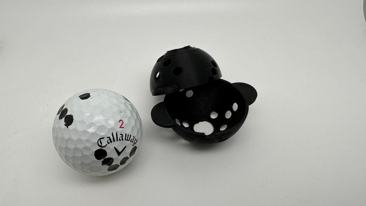 Marked golf ball beside the two printed halves of the downloadable ball marker