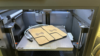 Close-up of the dual charger on the printer build plate
