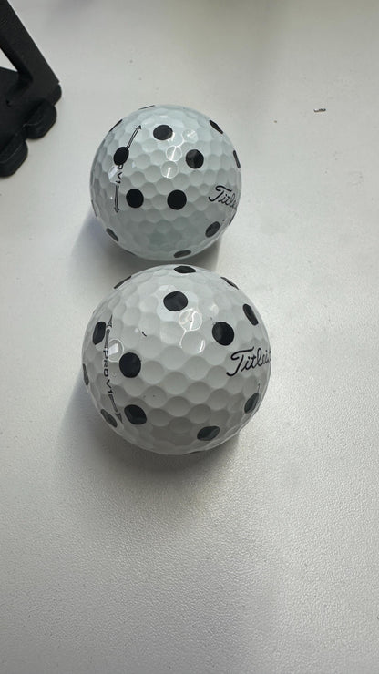 Two golf balls with matching markings made using the printed marker