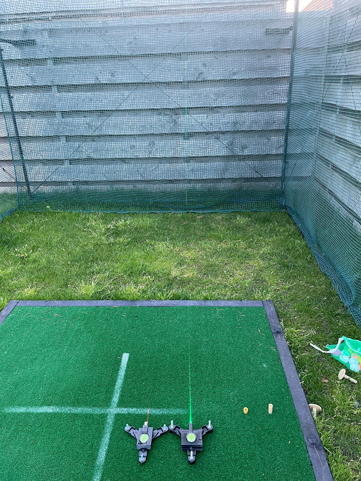 Outdoor golf mat showing red and green laser alignment lines