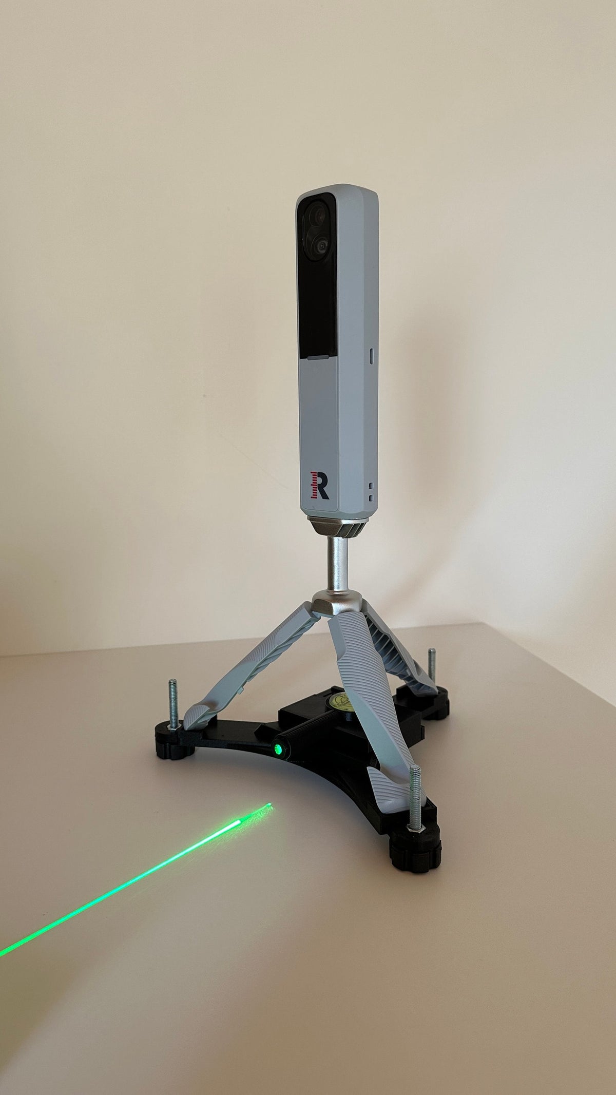 Rapsodo MLM2PRO on its adjustable stand with a green laser alignment line
