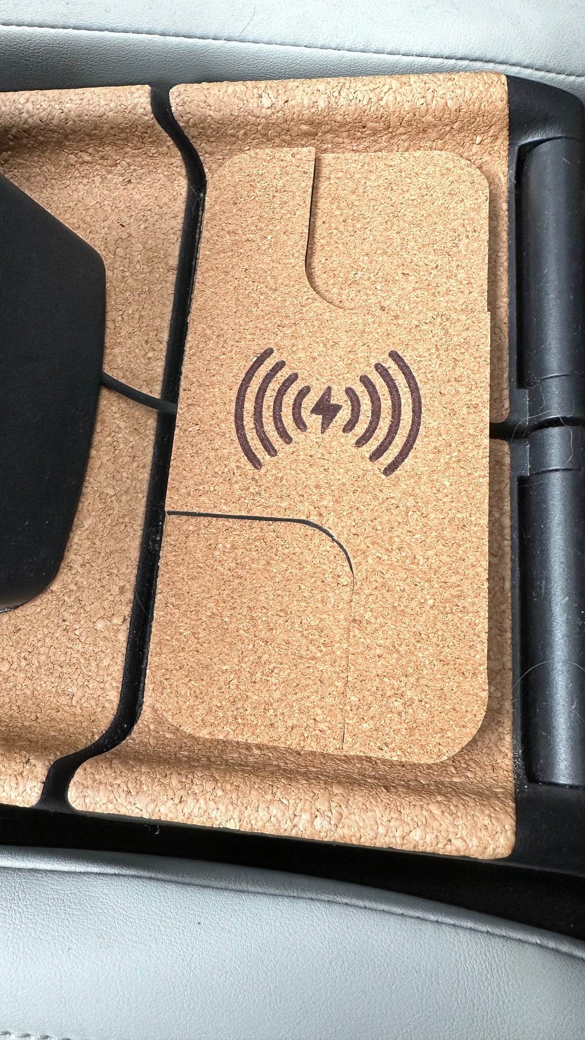 Close-up of the wireless charging symbol on the cork-finished MX-30 charger