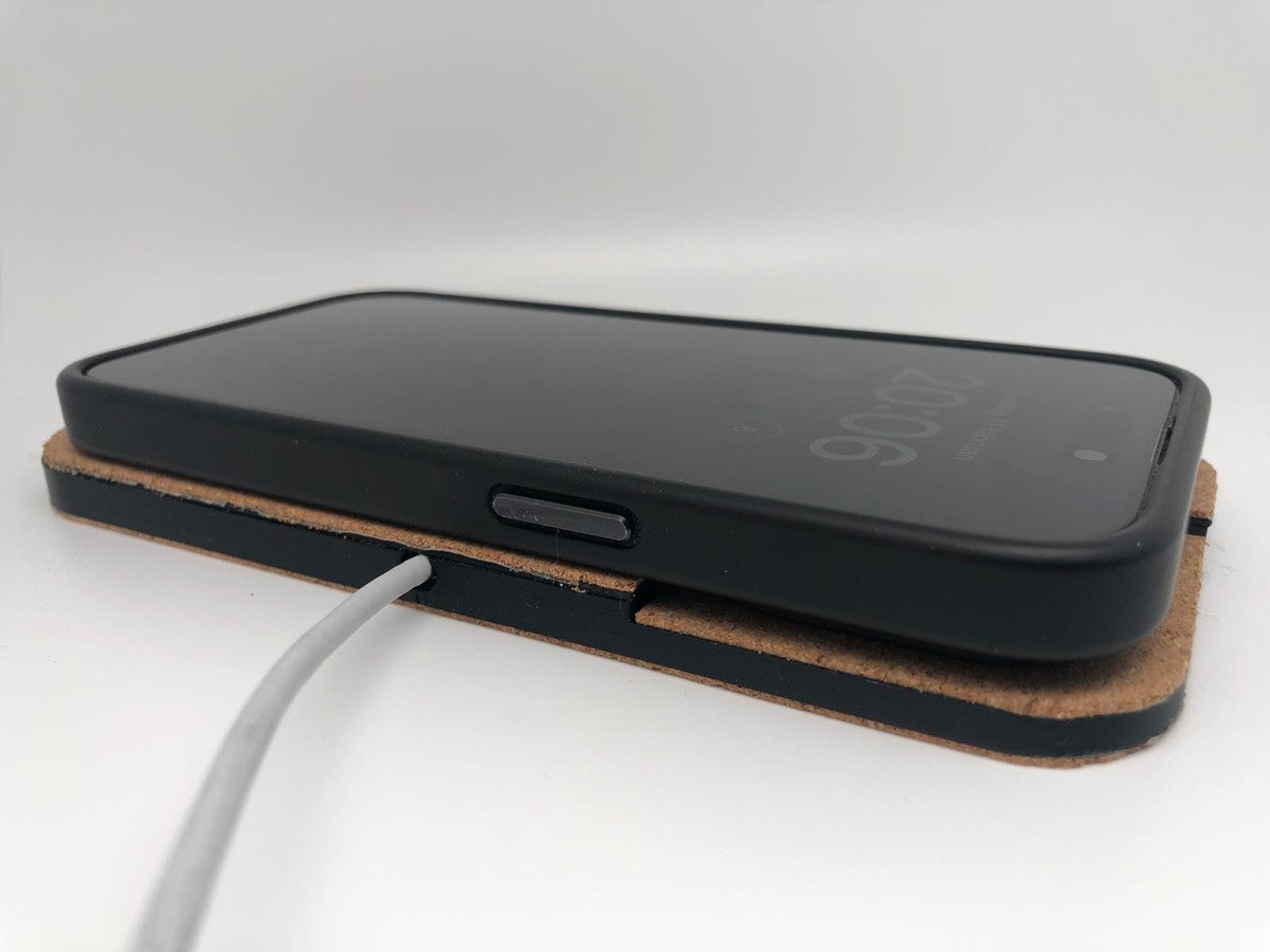 Side view of a smartphone resting on the cork-finished charging pad